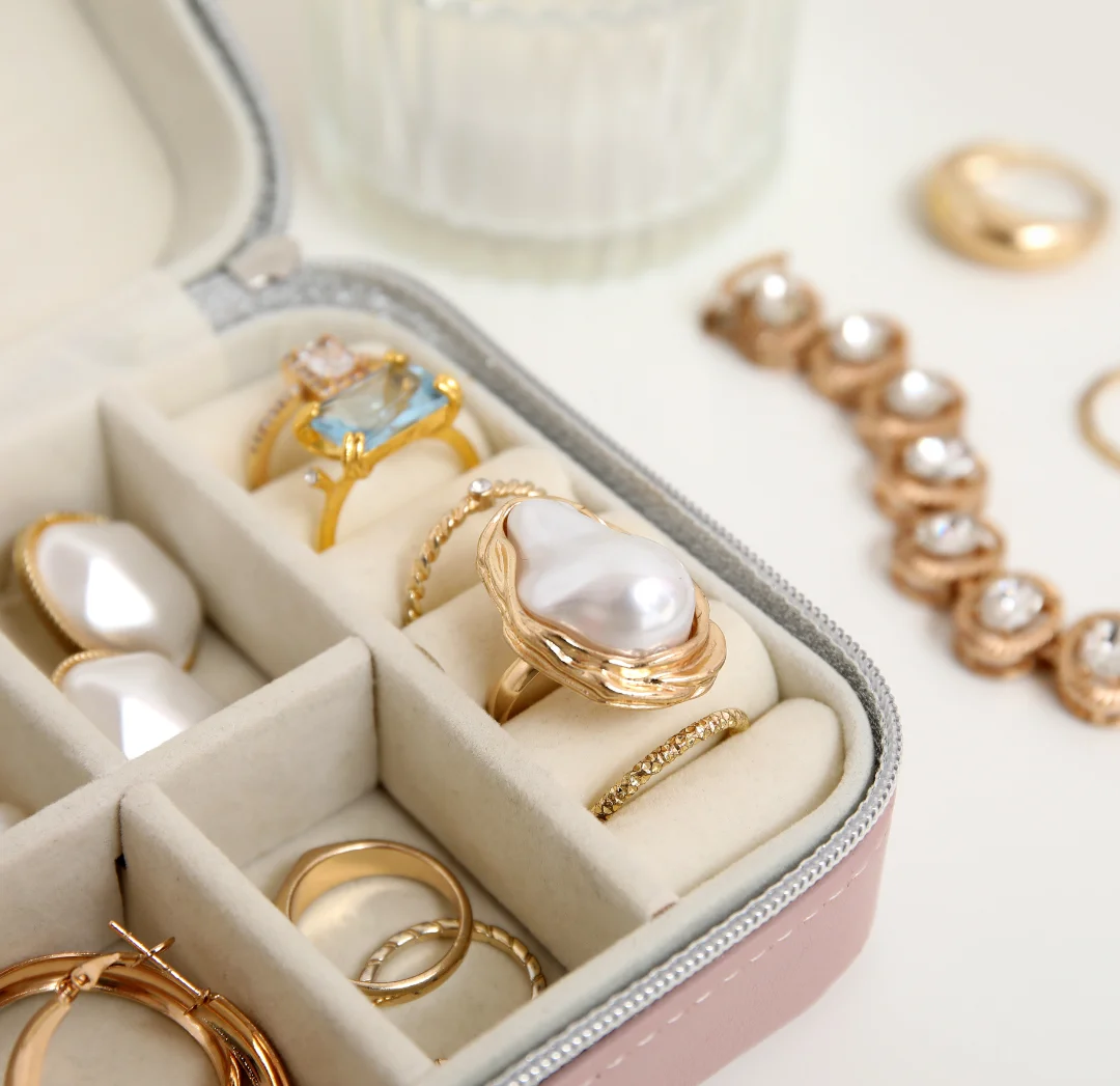 Organizador de joyas en el anillos de oro con cristales, anillos minimalista de oro, aretes de oro, en estuche para joyas de mujer, al lado collar de oro con diamantes